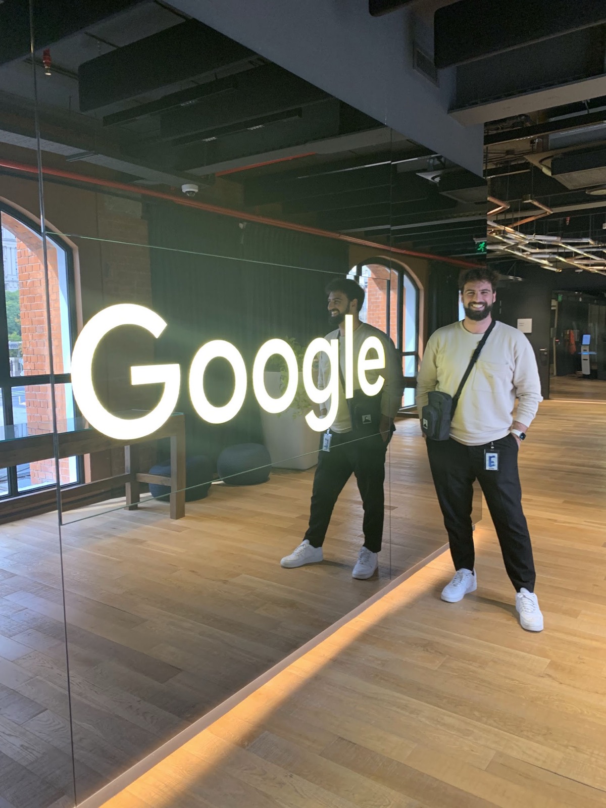 Standing next to an illuminated Google sign in a Google office.